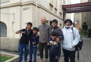 Estudante da SP Escola de Teatro e crianças e adolescentes bolivianos em frente ao prédio da sede Brás