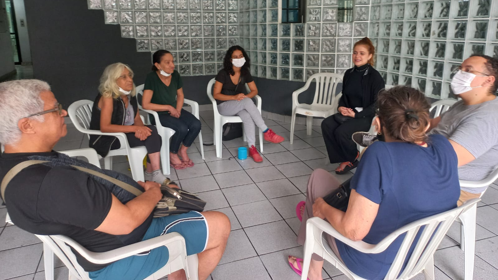 Estudantes da SP Escola de Teatro e idosos do Centro de Acolhida Especial sentados em círculo em atividade de contrapartida