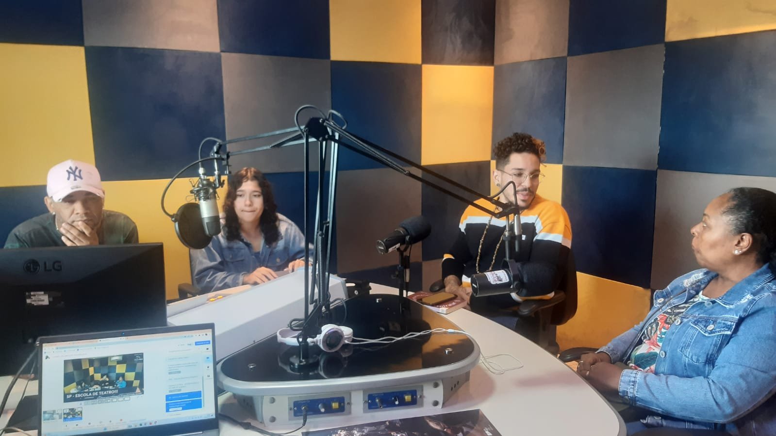 Foto colorida no estúdio da Rádio Comunitária Heliópolis, com João Martins e Mônica Madureiro, colaboradores da SP, e Ana e Wagner, representantes da rádio e da Unas