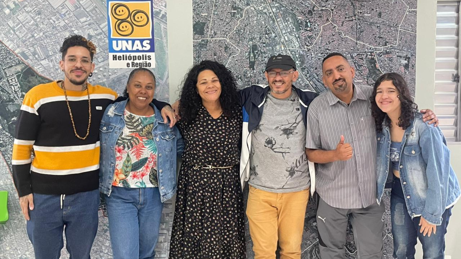 Foto colorida com João Martins, do Programa Oportunidades, Mônica Madureiro, bibliotecária da SP, e outras quatro pessoas da Unas