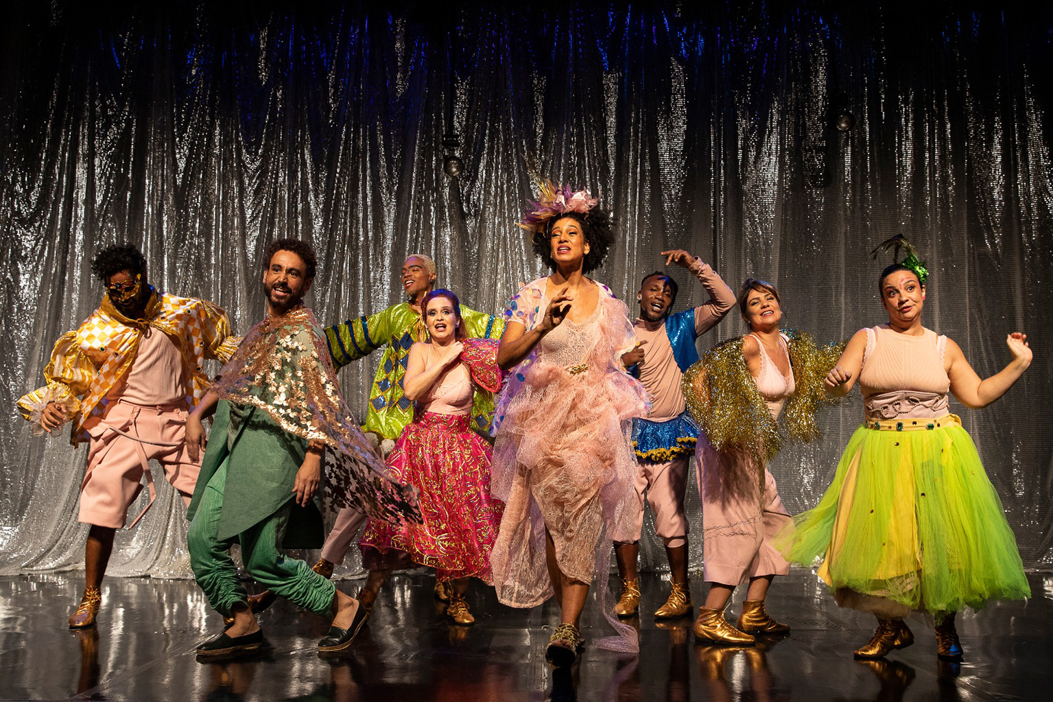Imagem colorida de atores em cena, no palco, para a peça "Salvador, Anoiteceu e é Carnaval"