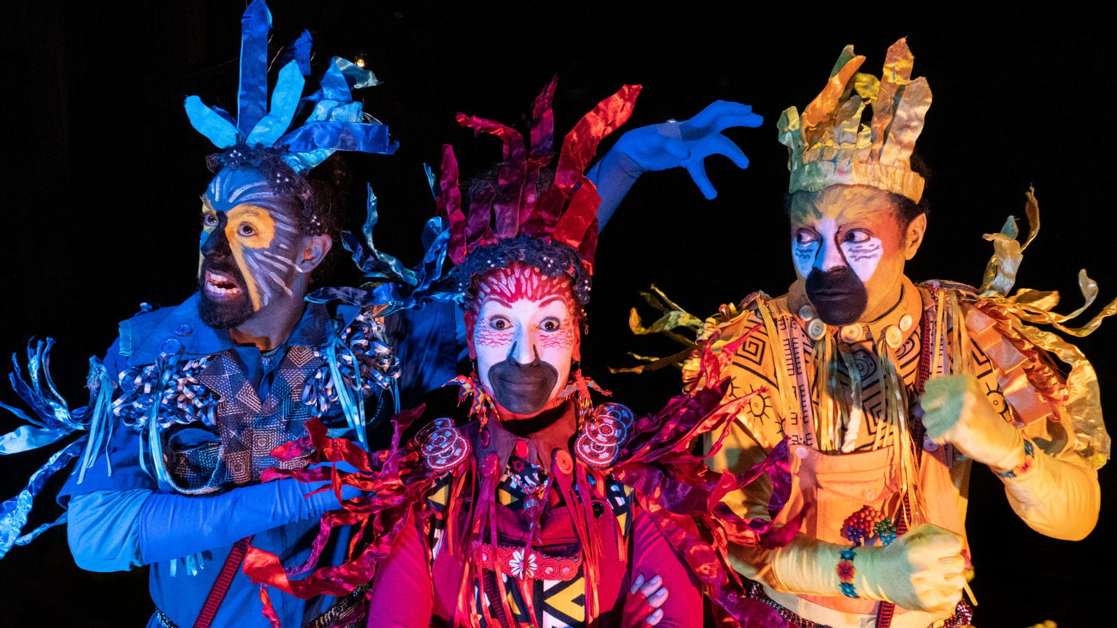 Fotografia colorida mostrando os três personagens do espetáculo "Os Coloridos" da Cia. Os Crespos
