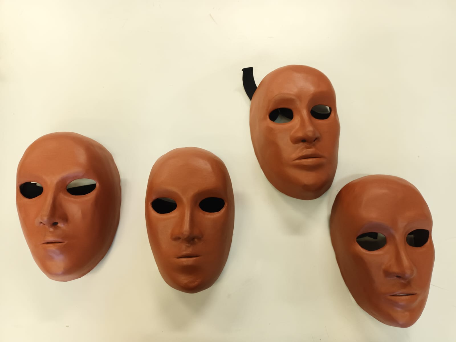 Fotografia colorida de quatro máscara neutras na cor marrom