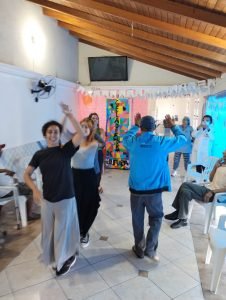 Fotografia colorida dos estudantes da SP Escola de Teatro na atividade de contrapartida no Centro de Acolhida Especial para Idosos do Brás