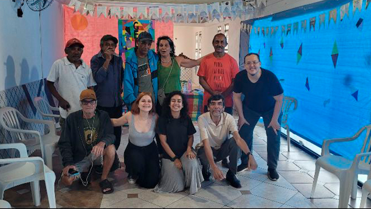 Fotografia colorida dos estudantes da SP Escola de Teatro na atividade de contrapartida no Centro de Acolhida Especial para Idosos do Brás