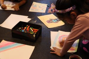 Fotografia colorida de uma criança imigrante na oficina do Programa Oportunidades em parceria com a Amilv