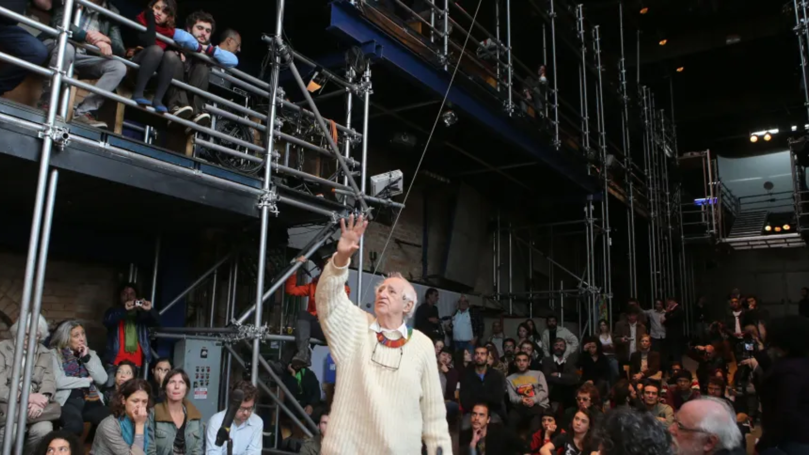 Fotografia colorida de José Celso durante audiência pública realizada no Teatro Oficina